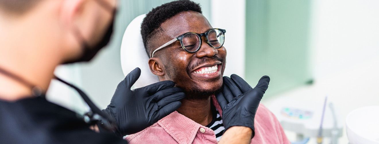 Dentist looking at patient's smile in treatment room