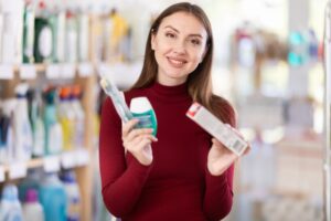 Woman holding teeth whitening products.